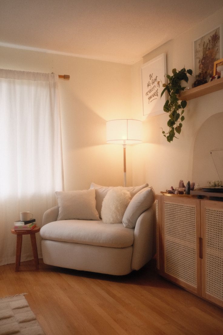 a living room filled with furniture and a lamp on top of a hard wood floor