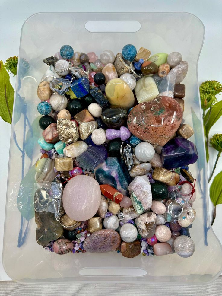 a plastic container filled with lots of different colored rocks and stones on top of each other