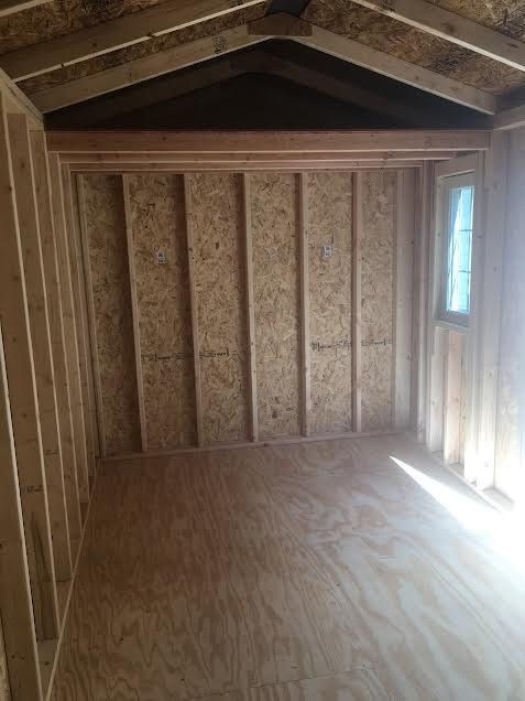 an empty room with wooden walls and wood flooring in the house that is being built