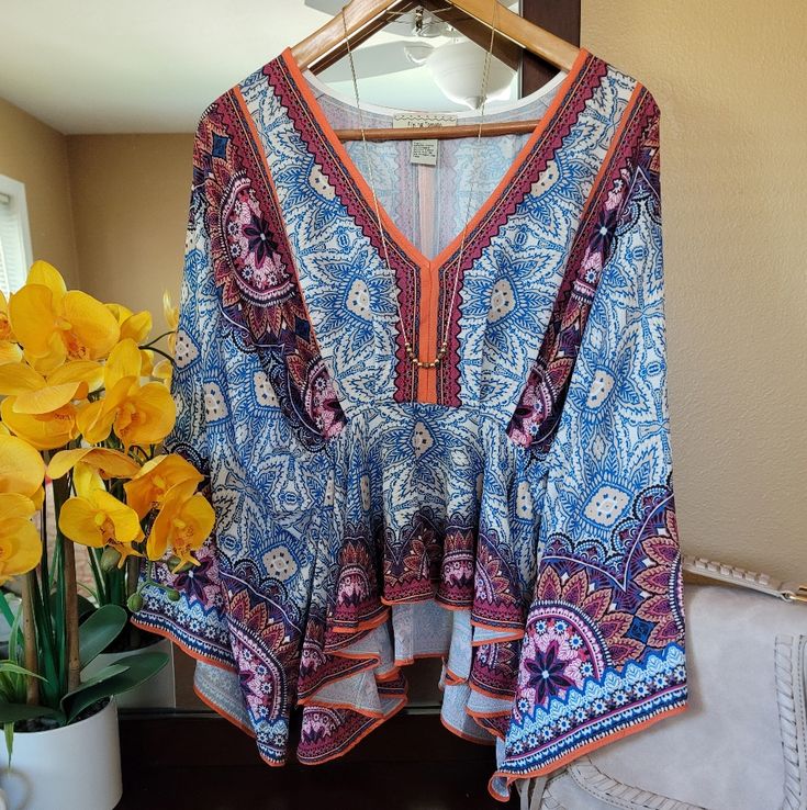 Nwot. All The Bohemian Vibes With This Gem. Colors Are Super Vivid. Deep V-Neck. Empire Waist With A Ruffle Hem. Sleeves Stop At Elbow And Flare Out. Looks Great With A Bralette, Distressed Shorts And Gold Accessories. Bust: 19-20 Inches (Approximate) Length: 23 Inches Shoulder To Hem Multicolor Floral Print V-neck Peasant Top, Peasant Style V-neck Blouse For Brunch, Patterned Flowy V-neck Blouse, Bohemian Patterned V-neck Peasant Top, Blue Vibrant Print V-neck Top, Blue Bohemian Printed Peasant Top, Floral Print V-neck Peasant Top For Beach, Purple Bohemian Peasant Top, Peasant V-neck Blouse For Brunch