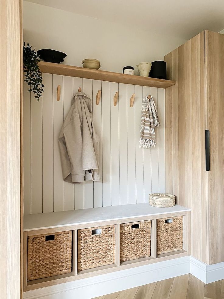 a coat rack with baskets and coats hanging on it's sides next to a bench