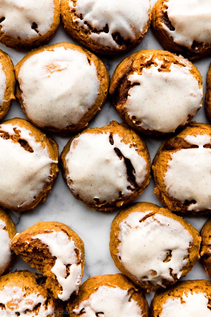 cookies with white icing and chocolate chips on a marble counter top, ready to be eaten