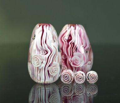 three pink glass vases sitting on top of a black table next to each other