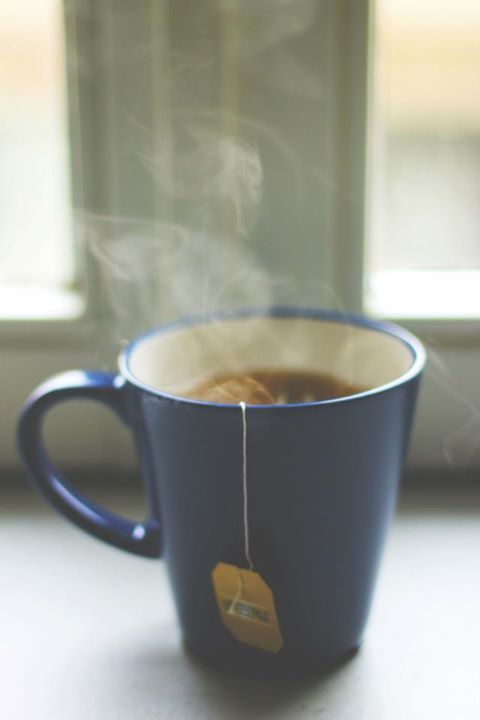 a cup of hot coffee with steam rising from it