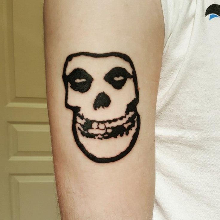 a man with a skull tattoo on his arm