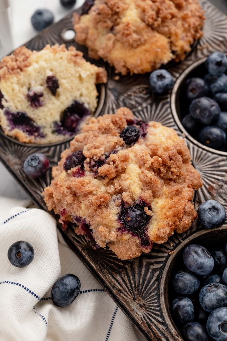 muffins with blueberries and crumbs on a tray