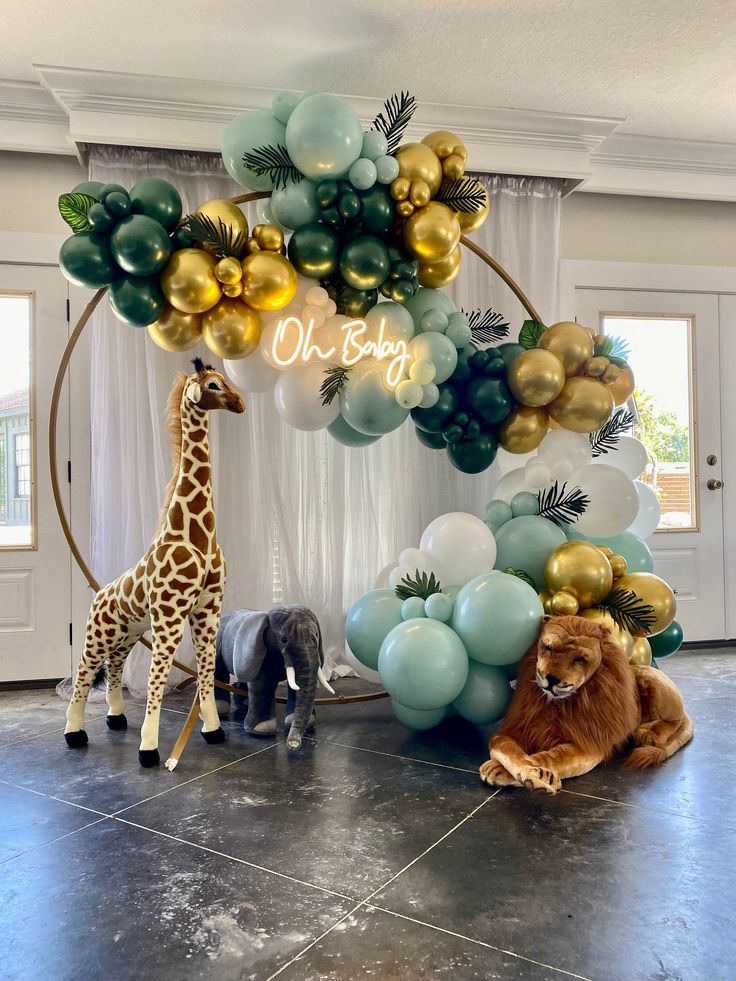 a giraffe, lion and elephant are on the floor in front of balloons