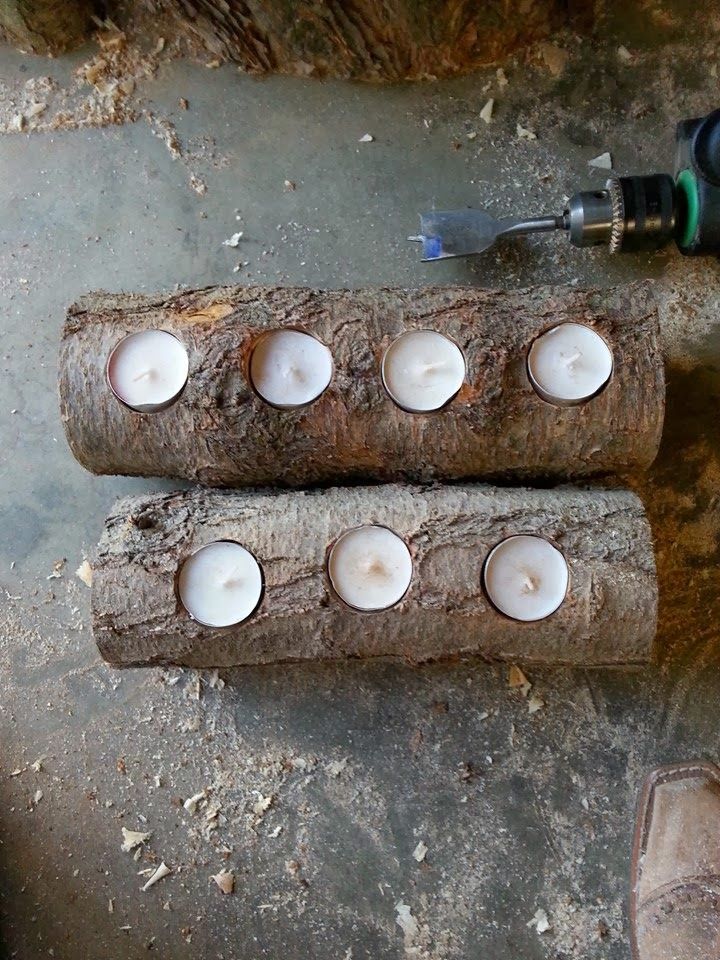 three logs with candles sitting on top of them