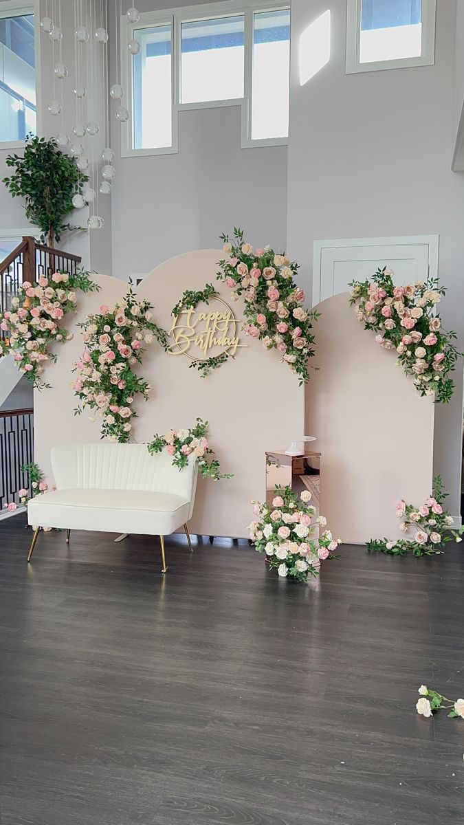 the wedding stage is decorated with pink flowers and greenery for an elegant touch to the venue