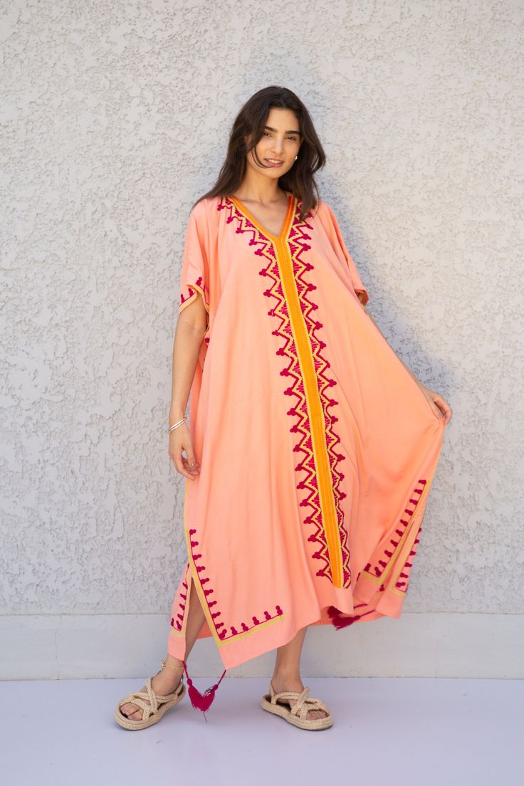 "This beautiful free size Kaftan has a unique presence to it. It's colorful and most importantly comfortable wear, light and soft and can be used on many occasions - home gatherings, dinners, or just in your home to feel comfortable. Fabric : 80% Egyptian Cotton and 20% Polyester Measurements : Free size. Fits up to 4XL. Also there is a belt that can be used to tighten the dress around the hips. Bust size : 67 inches Length : 57 inches **Note : The kaftan in the video is a different color of the Bohemian Pink Dress With Resham Embroidery, Bohemian Beach Kaftan With Geometric Embroidery, Bohemian Kaftan With Geometric Embroidery For Beach, Summer Maxi Kaftan With Resham Embroidery, Beach Kaftan With Resham Embroidery In Maxi Length, Geometric Embroidered Kaftan For Vacation, Traditional Pink Short Sleeve Maxi Dress, Pink Embroidered Maxi Dress For Vacation, Geometric Embroidery Kaftan For Vacation