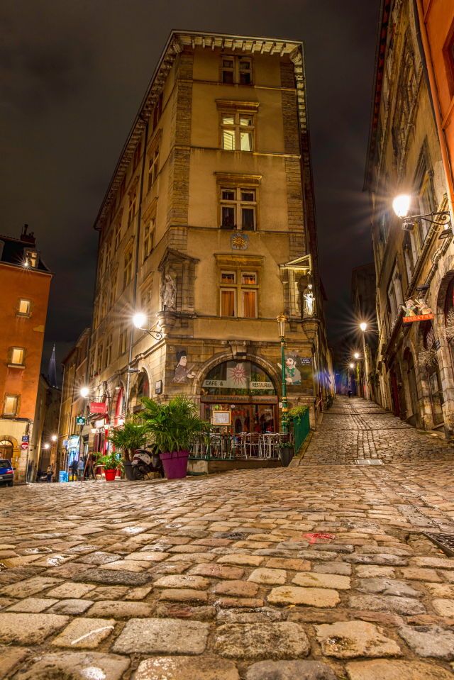 an empty cobblestone street in the city at night