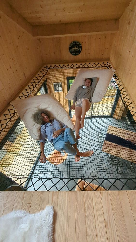 two people are laying on bean bags in a room with wood walls and flooring