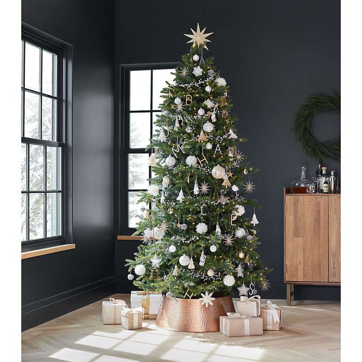 a decorated christmas tree in a living room with presents on the floor next to it