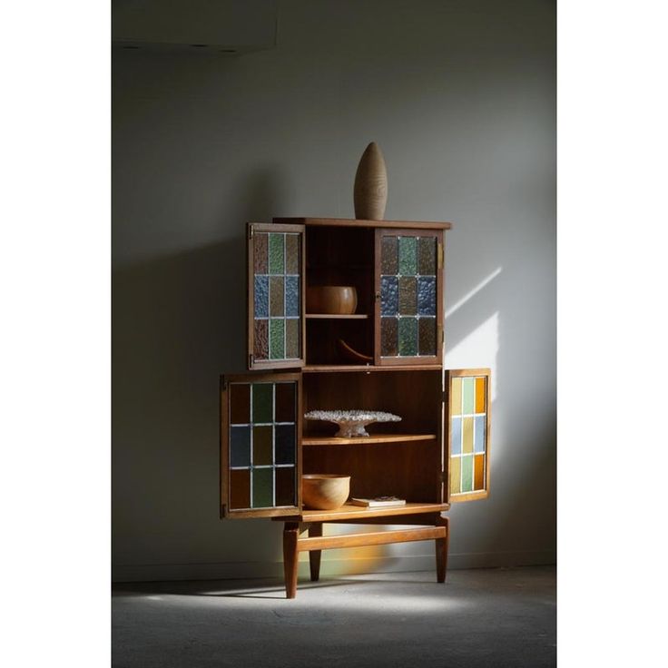 a wooden cabinet with many different colored glass pieces on it's doors and shelves