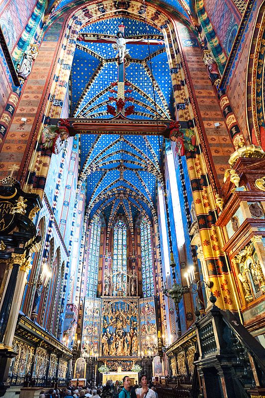 the inside of a church with many stained glass windows and high vaulted ceilings, all decorated in different colors