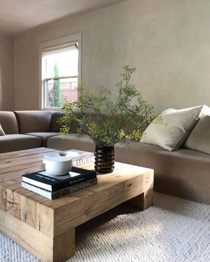 a living room with a couch, coffee table and books on top of the tables