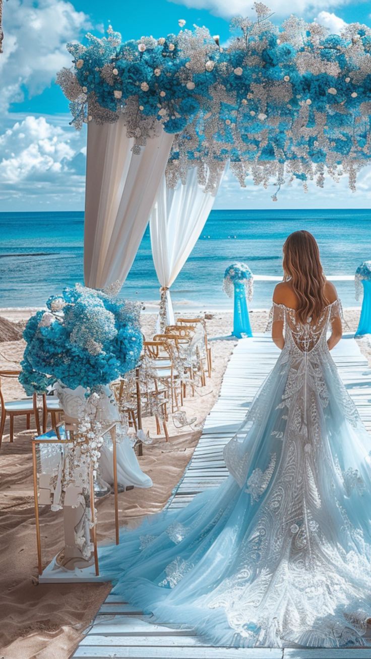 A bride stands at a beautifully decorated beach wedding entrance, surrounded by stunning seaside decor, ready for her special day. Blue Beach Wedding Decorations, Beach Venues For Weddings, Wedding Decorations Beach Theme, Wedding Venues By The Sea, Wedding Arches Beach, Unique Wedding Location Ideas, Sunflower Beach Wedding Ideas, Cute Beach Wedding Ideas, Beach Color Wedding