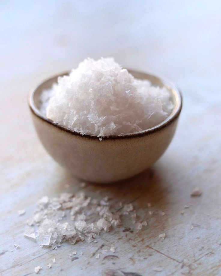 a small bowl filled with sugar on top of a wooden table