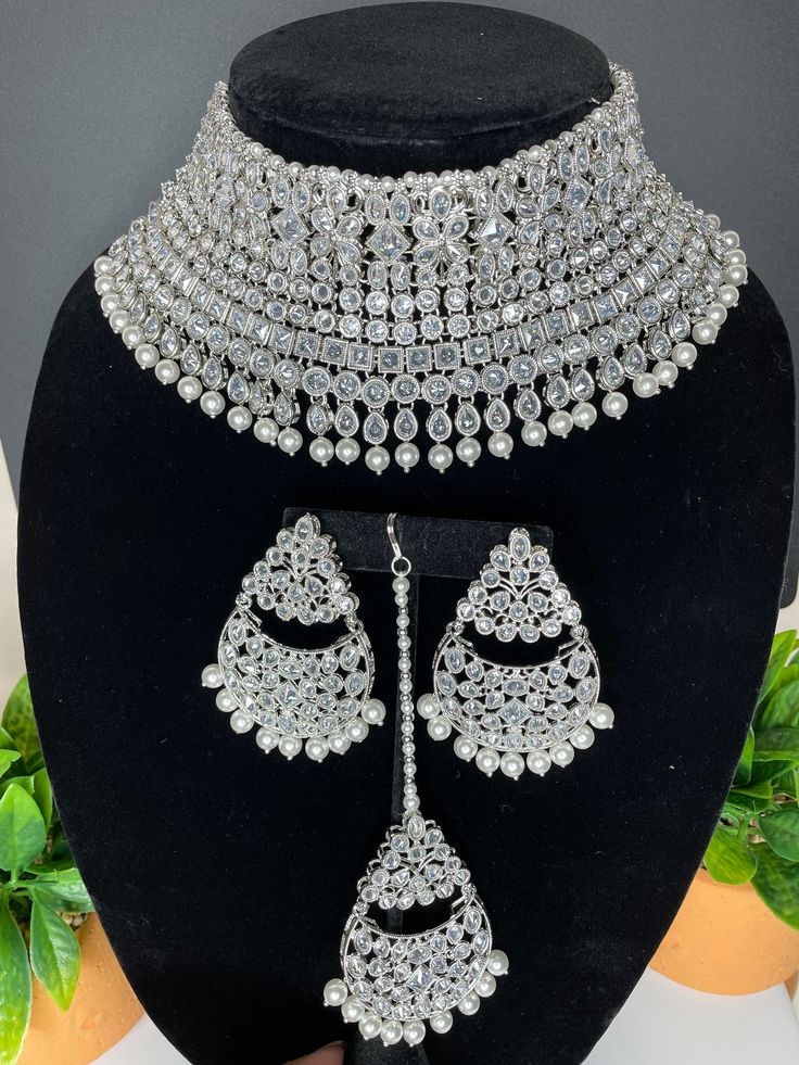 This elegant and gorgeous choker with matching earrings and tikka is sure to be a hit for any event! The neutral colors can match any outfit and the colors are perfect for any summer occasion! It comes in 2 beautiful tones with a pastel pink and copper and a silver finish look as well. It hugs the neck and is made of high quality stones. Sabyasachi Bridal Jewellery Set, Cheap Silver Kundan Necklace Gift, Silver Kundan Necklace For Reception With Intricate Design, Silver Kundan Necklace With Intricate Design For Reception, Traditional Silver Bridal Necklace With Stone Work, Silver Choker With Intricate Design For Wedding, Silver Kundan Necklace For Reception With Stone Work, Silver Kundan Necklace With Stone Work For Reception, Silver Heavy Chandbali Jewelry Sets