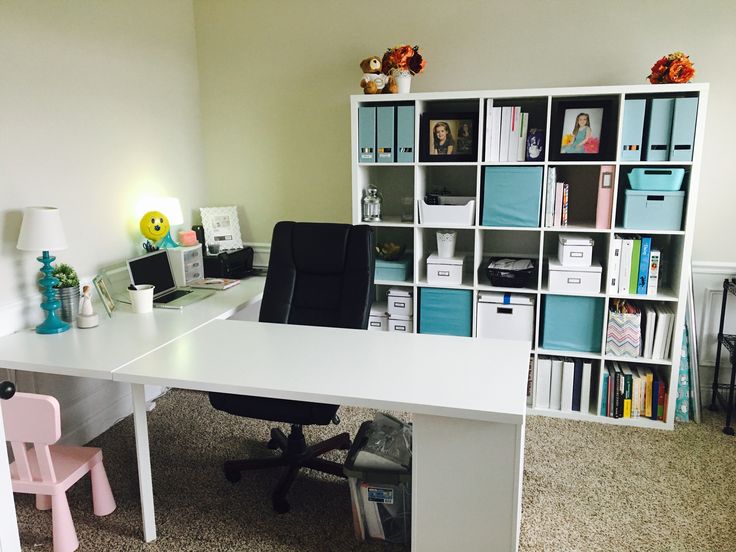 a white desk sitting in front of a bookshelf filled with lots of shelves