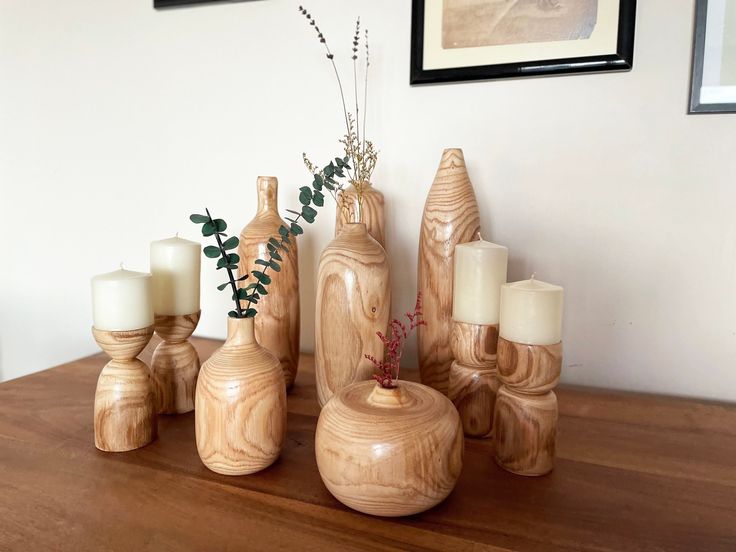 a wooden table topped with vases and candles