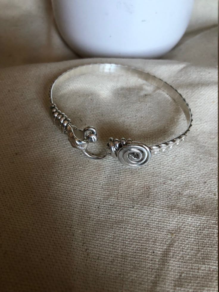 This is a handcrafted bangle/bracelets. It is designed with an oval shape to ensure a proper fit. It is the perfect gift for mothers, sisters, birthdays, daughters, and lovers. This is a simple classy bracelets.  It is  5mm in wide, , handcrafted wire-wrapped bangle bracelet, wire wrapped in sterling silver. A dainty, elegant bracelet that can be used as statement jewelry. As a Caribbean person St.Croix born and raised) these hook-styled bracelets are known to bring good luck or a meaningful ges Handmade Sterling Silver Bangle In Spiritual Style, Handmade Spiritual Sterling Silver Bangle, Elegant Spiral Hand Wrapped Jewelry, Sterling Silver Wire Wrapped Bangle Jewelry, Sterling Silver Wire Wrapped Bangle, Artisan Silver Bangle Hand Wrapped, Handmade Oval Sterling Silver Bracelet Gift, Handmade Oval Sterling Silver Bracelet For Gift, Artisan Hand-wrapped Silver Bangle