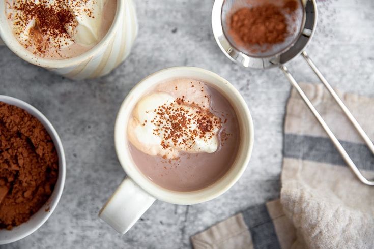 three mugs filled with hot chocolate and topped with cinnamon sprinkled on top