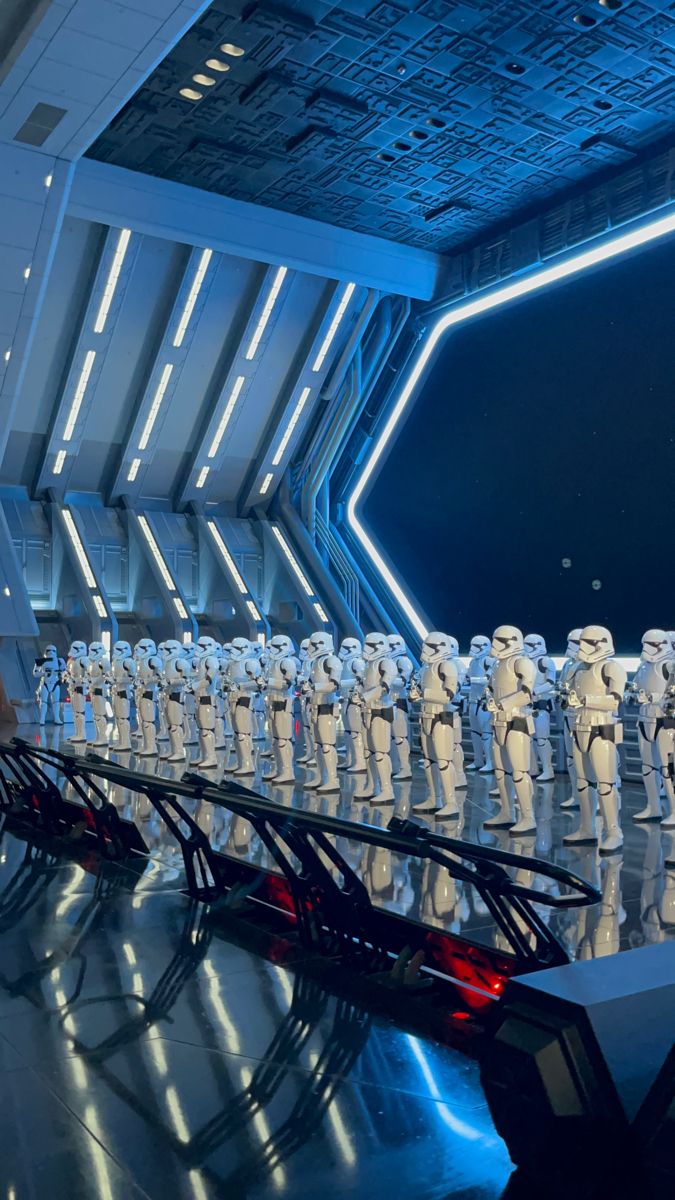 a group of star wars characters lined up in front of a stage with lights on