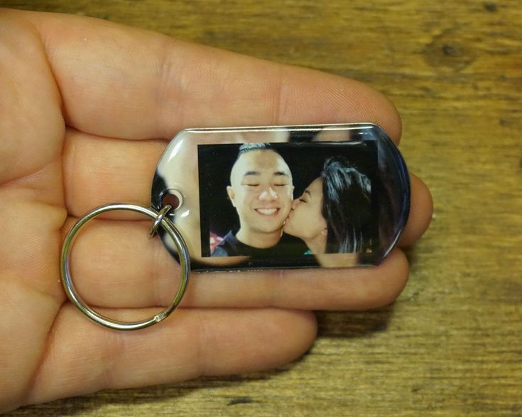 a person holding a keychain with a photo on it