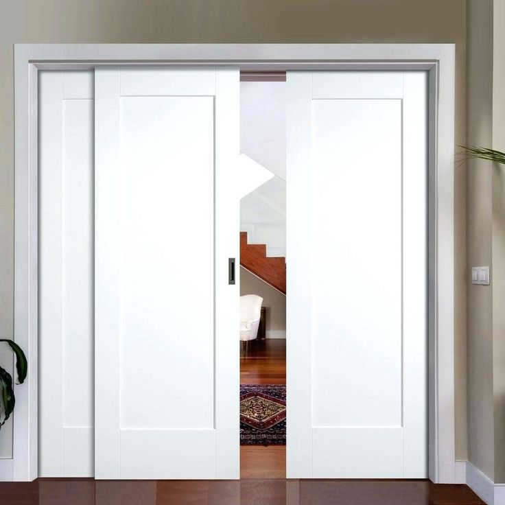 an open white door in a room with hardwood floors