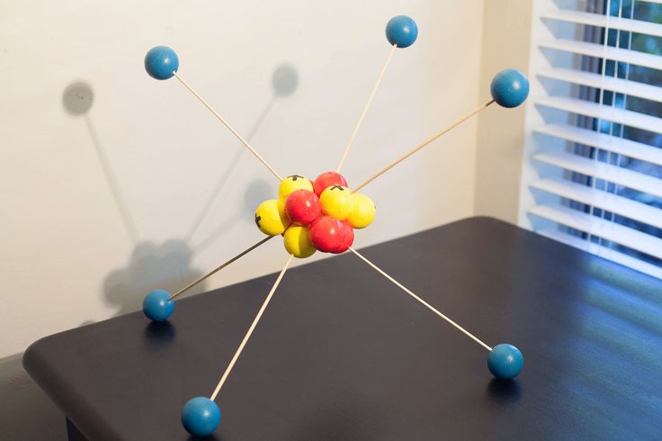 a table with some balls and pins on it in front of a window that has blinds