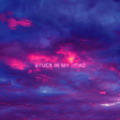 the words stuck in my head are lit up against a purple and blue cloudy sky