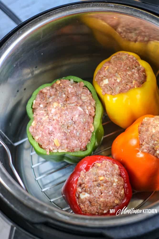 three peppers with meat in them sitting inside an air fryer