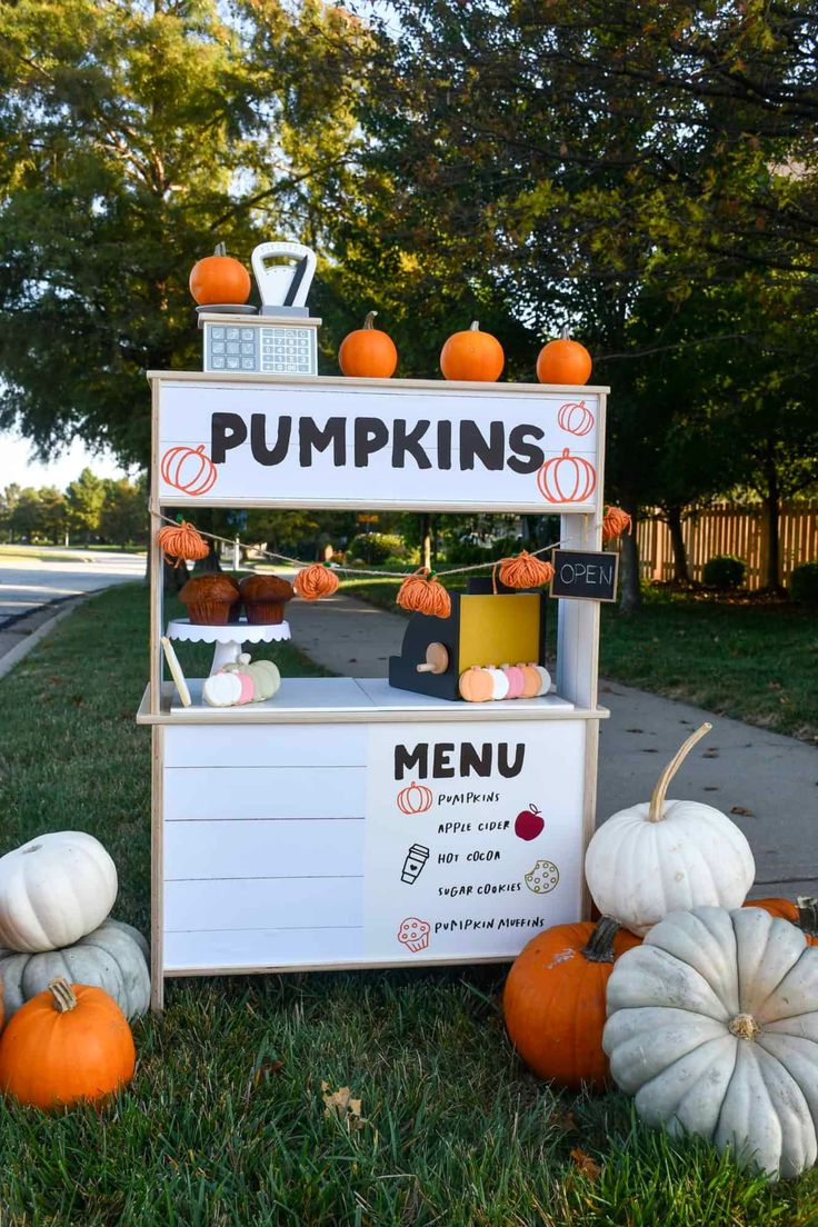 some pumpkins are sitting on the grass near a sign that says pumpkins menu