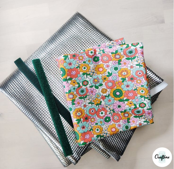 three napkins on top of each other with green ribbon and flower designs in them