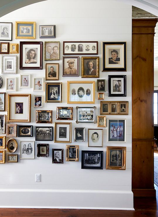 black and white photograph of a wall with many framed pictures hanging on it's side