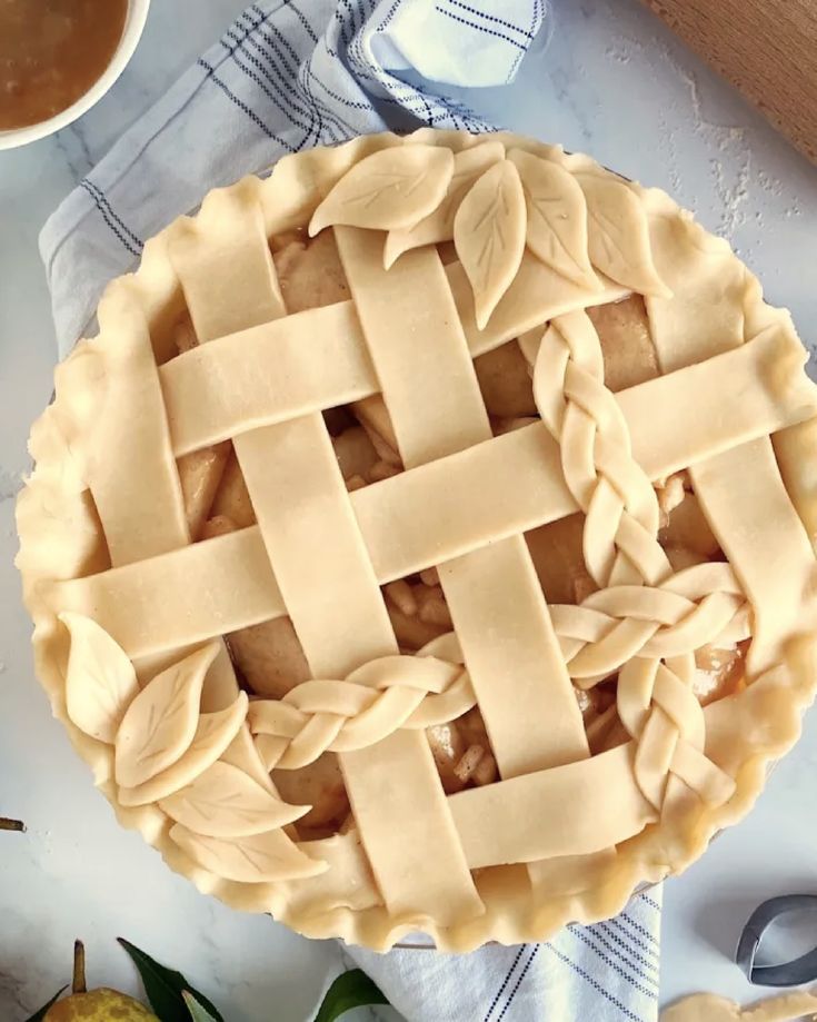 a pie sitting on top of a table next to some pears