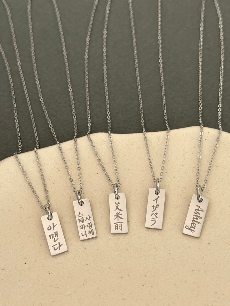 This listing is for a personalized engraved Japanese name dainty tag necklace in stainless steel. Stainless steel jewelry is strong and almost never tarnish or corrode.  The sample necklaces are engraved with Isabella in Japanese in the font #5 vertically and You are beautiful in Japanese in the font #2 in two vertical lines. If there are many characters, they will be engraved in two lines. Please check the font options in the pictures. The tag pendant is 6 mm wide and 15 mm high. The necklace is a 45 cm (17 inches) with a 5 cm (2 inches) extender chain. All orders come gift-wrapped. << How to order >> Please choose engraving side from the options. Please leave the name or word and font style number you want. If you don't choose a font, the font #5 used for the sample will be used. If you Minimalist Laser Engraved Rectangular Necklace, Minimalist Rectangular Laser Engraved Necklace, Silver Necklace With Engraved Rectangular Pendant, Everyday Rectangular Necklace With Engraved Text, Everyday Rectangular Necklaces With Engraved Text, Everyday Rectangular Engraved Text Necklace, Rectangular Stainless Steel Necklaces With Engraved Text, Rectangular Stainless Steel Necklace With Engraved Text, Personalized Rectangular Spiritual Necklace