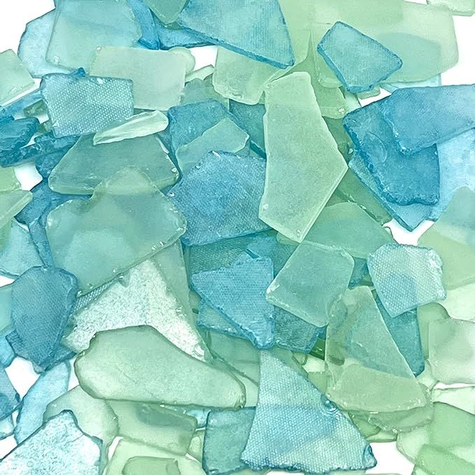 some blue and green glass pieces on a white surface