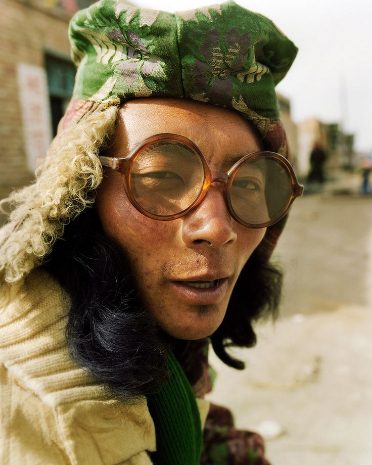 a woman wearing glasses and a hat on top of her head