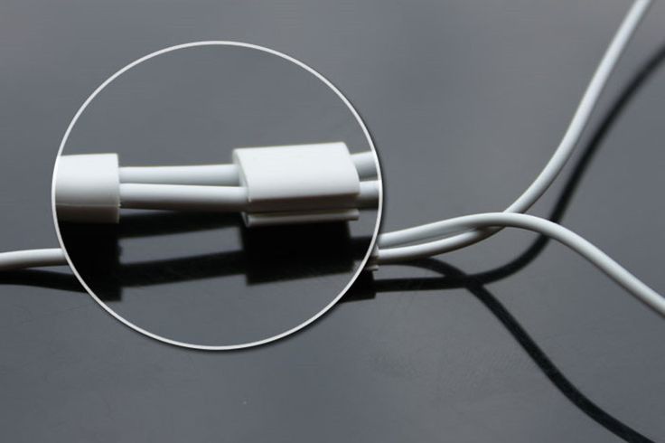 two white wires connected to each other on a black surface with an oval hole in the middle