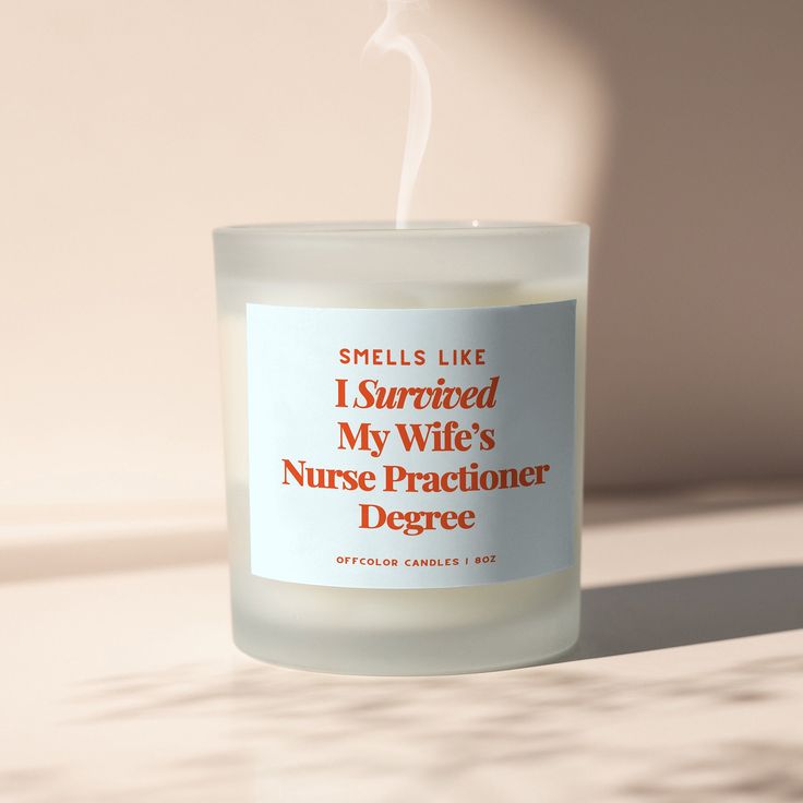 a candle that is sitting on a table with the words, smells like i survived my wife's nurse practice degree