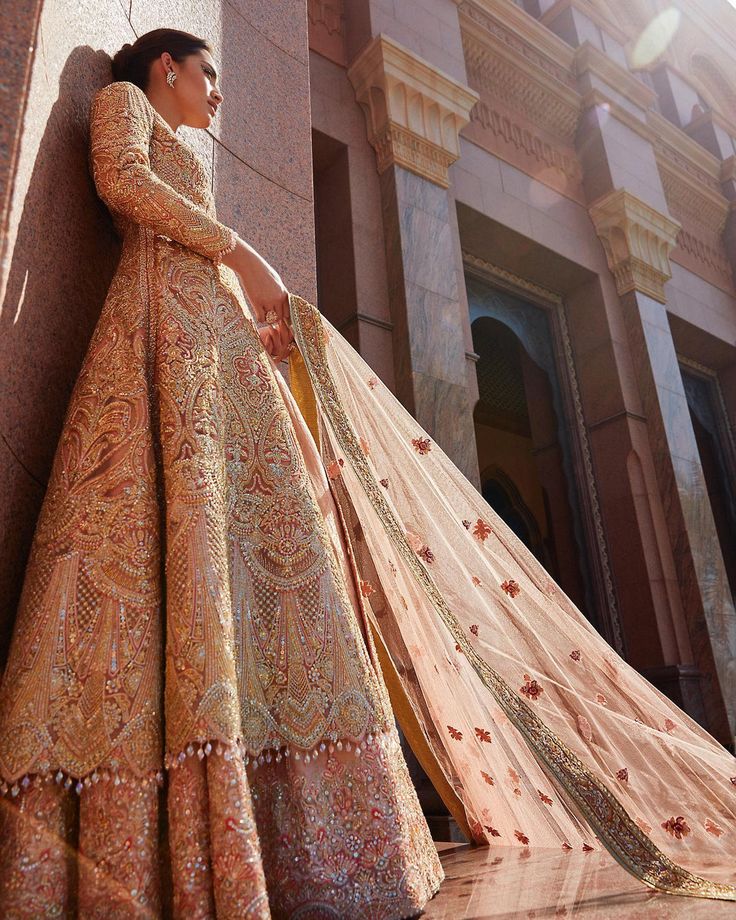 a woman in a wedding dress leaning against a wall