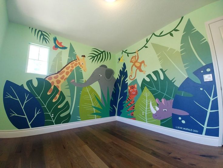 an empty room with painted jungle animals on the wall and wooden floors in front of it