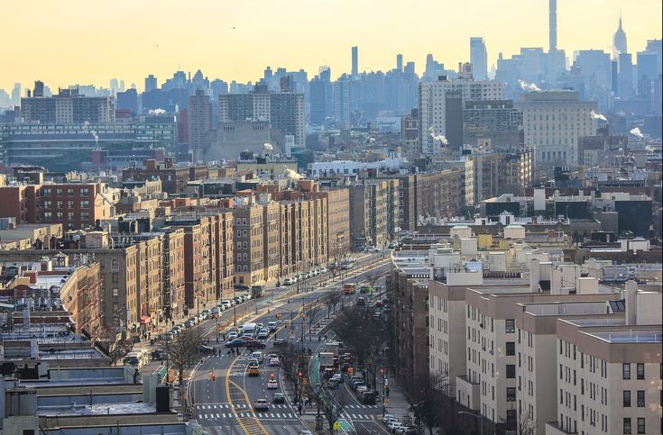 an aerial view of a city with tall buildings in the foreground and cars driving on the street