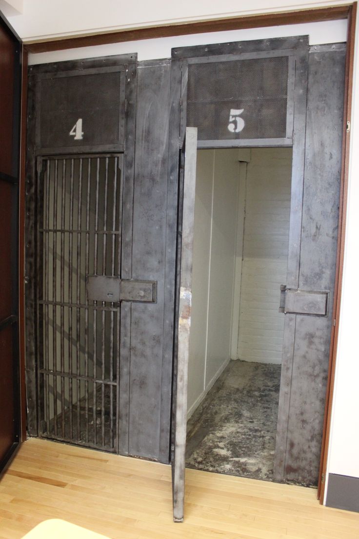 an empty room with metal bars and numbers on the doors