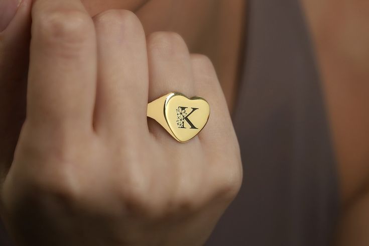 Celebrate love and individuality with this exquisite Heart-Shaped Gold Signet Ring, featuring a beautifully engraved flowered letter initial. This personalized piece combines the timeless elegance of gold with the romantic touch of floral design, making it a perfect expression of affection and personal style. Ideal for anniversaries, Valentine's Day, or as a meaningful gift, this ring captures the essence of romance and bespoke craftsmanship. Embrace the beauty of personalized jewelry and make a Dainty Engraved Ring With Initials For Gift, Elegant Stamped Heart-shaped Jewelry, Dainty Engraved Ring With Initials For Anniversary, Elegant Engraved Signet Ring For Valentine's Day, Elegant Stamped Jewelry For Valentine's Day, Fine Jewelry Initial Ring With Engraving Option, Fine Jewelry Initial Ring With Engraving Option As Gift, Vintage Initial Ring For Gifts, Heart Shaped Monogram Jewelry For Anniversary