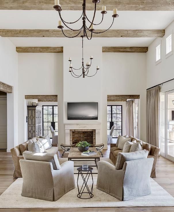 a living room filled with lots of furniture and a chandelier hanging from the ceiling