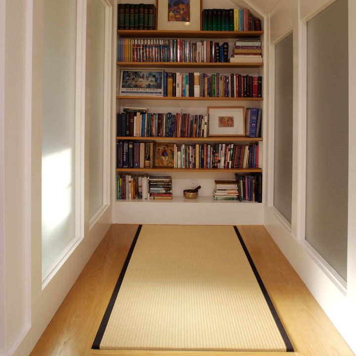 an empty room with bookshelves and rug on the floor