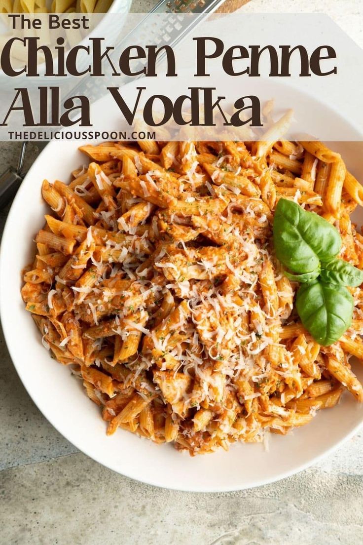 the best chicken penne alla vodka recipe on a white plate with basil sprigs